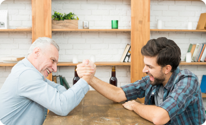 aged-man-young-guy-with-hands-clasped-arm-wrestling-challenge-table-room